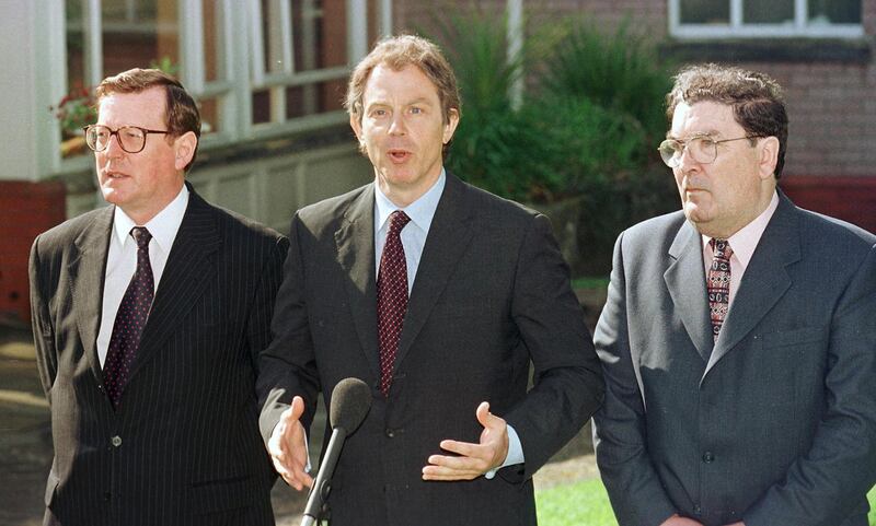 Tony Blair, centre, talks to the media after a meeting with David Trimble, left, and John Hume. AFP