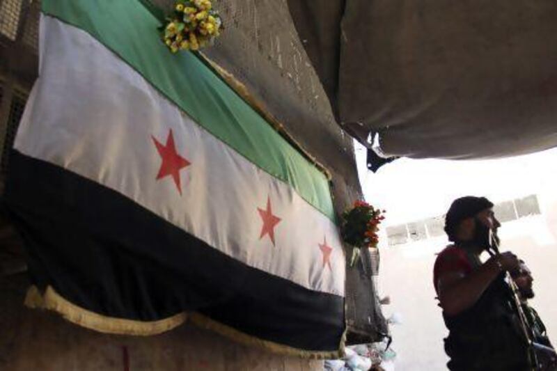 Free Syrian Army fighters near an opposition flag at their post in Aleppo's Bustan  Al Qasr.