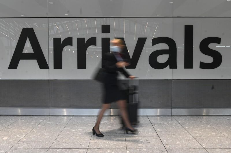 A pasenger pulls her roller suitcase on arrival in Terminal 5 at Heathrow airport in London, on June 3, 2021. Health Secretary Matt Hancock has said it remains "too early" to say whether all coronavirus restrictions can end on June 21.  Speaking ahead of a G7 health ministers' meeting, he told reporters: "It's too early to say what the decision will be about step four of the road map, which is scheduled to be no earlier than June 21.

 / AFP / DANIEL LEAL-OLIVAS
