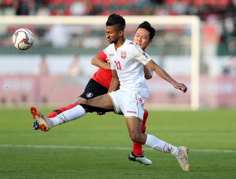 Dubai, United Arab Emirates - January 22, 2019: Jung Woo-young of South Korea and Mohamed Al Romaihi of Bahrain battle during the game between South Korea and Bahrain in the Asian Cup 2019. Tuesday, January 22nd, 2019 at Rashid Stadium, Dubai. Chris Whiteoak/The National