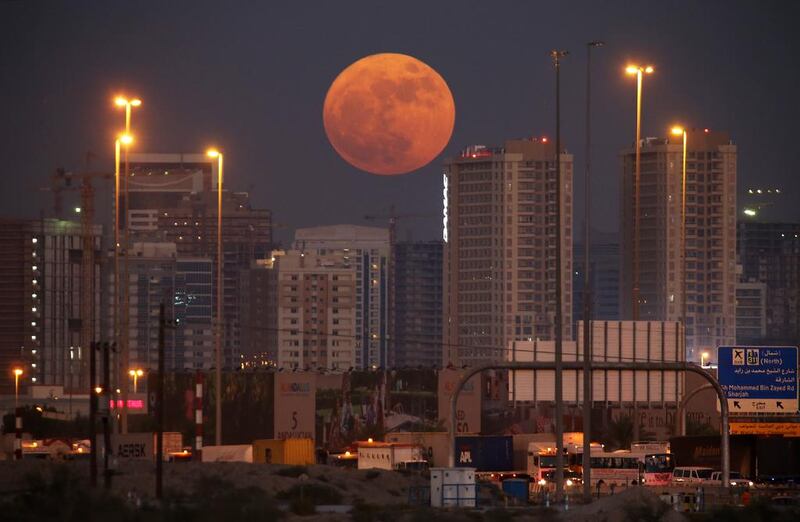 The supermoon hangs over the residential buildings in Dubai Sports City. Pawan Singh / The National
