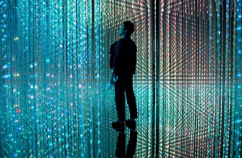 A visitor looks at a digital artwork on display in the 'Wander through the Crystal World' at the digital art museum.