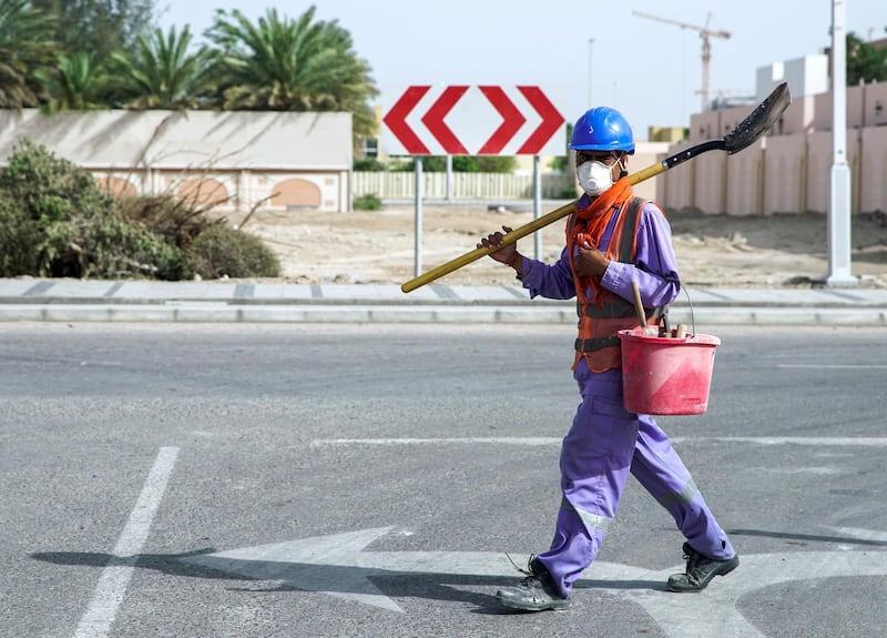 Abu Dhabi, United Arab Emirates, April 5, 2020.  A construction worker crosses the street with a mask on at Khalifa City, Abu Dhabi.  Face masks should be worn at all times when outside the home, the UAE government said on Saturday.              Victor Besa / The NationalSection:  NAReporter: