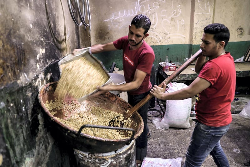 Egyptian confectioners add peanuts to melted sugar as they make sweets at a candy factory in the capital Cairo on November 2, 2019, ahead of celebrations of the Muslim Prophet Mohammed's birthday, known as "Al Mawlid Al Nabawi". - Prophet Mohamed was born in Saudi Arabia's arid mountainous city of Mecca, the holiest in Islam, some 1490 years ago. 
Sunni Muslims in many parts of the world celebrate his birthday on the 12th day of the third month of the Islamic calendar, which will fall this year on November 9th. (Photo by Mohamed el-Shahed / AFP)