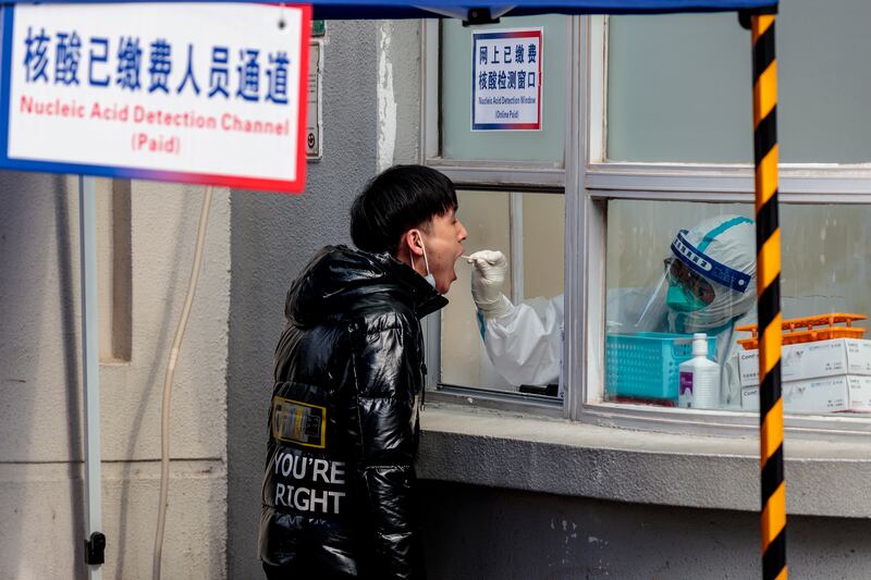 A resident gives a sample for a nucleic acid Covid-19 testing, in Shanghai. EPA