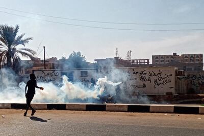 A protester throws tear gas canisters back at security forces during a rally to mark three years since the start of mass demonstrations that led to the removal of leader Omar Al Bashir, in the capital Khartoum. AFP