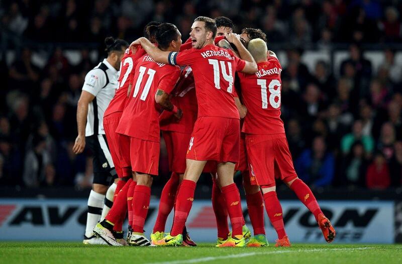 Liverpool players celebrate after defender Ragnar Klavan, centre obscured, scored the opening goal. Paul Ellis / AFP