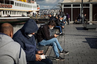 People browse smartphones at the passenger ferry pier in Istanbul, Turkey. Bloomberg