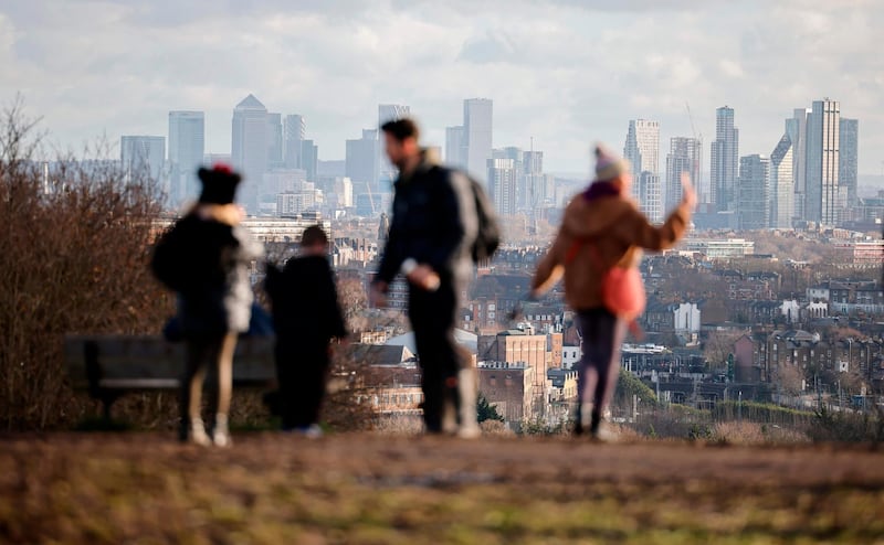 Members of the public take in a view of the London skyline from Parliament Hill on Hampstead Heath. AFP