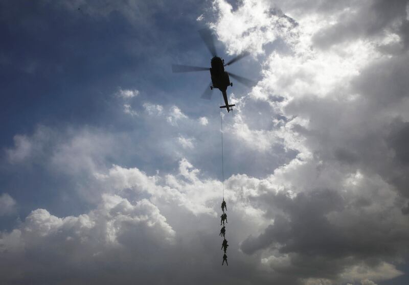 Members of Nepalese army hang on to the MI-17V-5 Helicopter during their rehearsal for the upcoming Army Day celebration at Tundhikhel in Kathmandu. Reuters