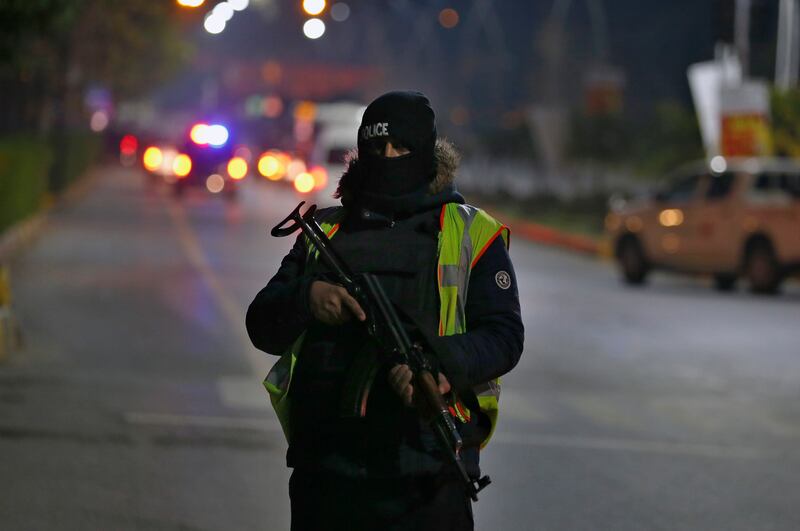 A police commando stands guard as security forces escort Australian players to the team hotel in Islamabad. AP