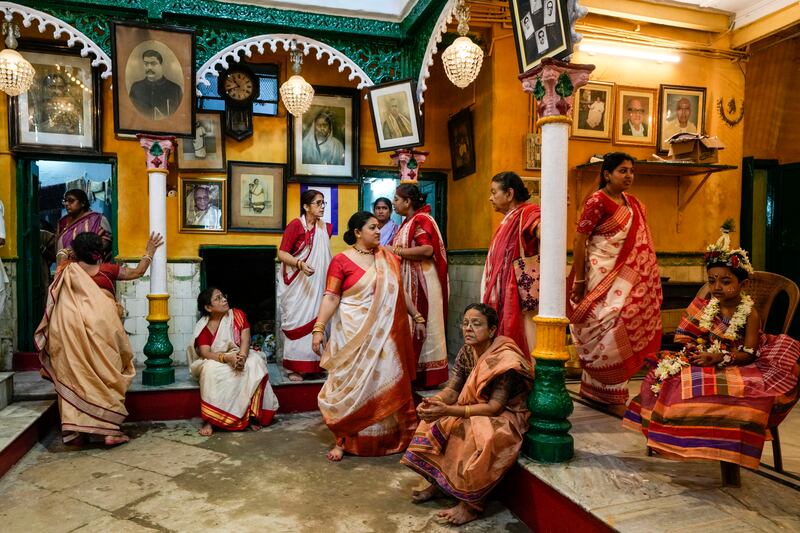 Women in traditional dress with a Kumari, right, a virgin girl worshipped as an incarnation of goddess Durga, during a Durga Puja festival, in Kolkata, India. The five-day festival commemorates the slaying of a demon king by lion-riding, 10-armed goddess Durga, marking the triumph of good over evil. AP Photo