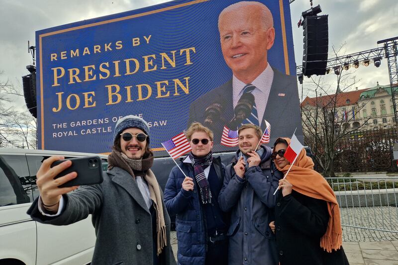 People wait for the arrival of Mr Biden. EPA