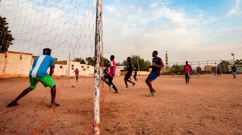 Sudanese youths play football on a dirt field in the capital Khartoum.