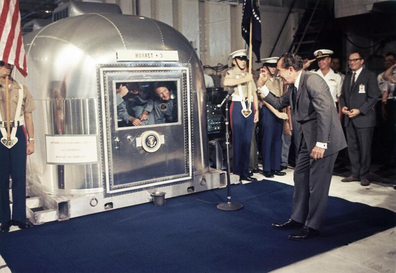 President Richard Nixon gives an "OK" sign as he greets Apollo 11 astronauts in a quarantine van aboard the USS Hornet. AP Photo