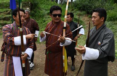 In this photo taken on August 25, 2018, Bhutanese archer Ygyen Dorji (C), a mental health counsellor and archery enthusiast, interacts with other archers during a practice tournament at the Changlimithang Archery Ground in Thimphu. The traditional sport is a way of life for some 800,000 people in the small Himalayan kingdom of Bhutan. - TO GO WITH Bhutan-archery-lifestyle,FEATURE by Abhaya Srivastava
 / AFP / ARUN SANKAR / TO GO WITH Bhutan-archery-lifestyle,FEATURE by Abhaya Srivastava
