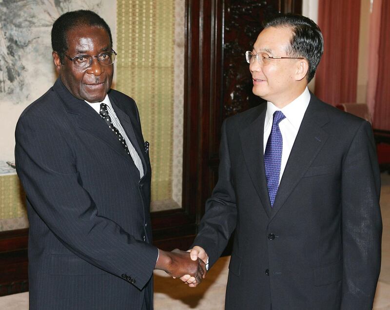 BEIJING - JULY 27:  Chinese Premier Wen Jiabao (R) geets Zimbabwe President Robert Mugabe on July 27, 2005 in Beijing, China. Following sanctions and isolation from Western countries over Mugabe's disastarous and criminal political reforms, Zimbabwe has turned to Asia, seeking to buttress political and trade relations in particular with China, Malaysia and Singapore. (Photo by Guang Niu/Getty Images) 