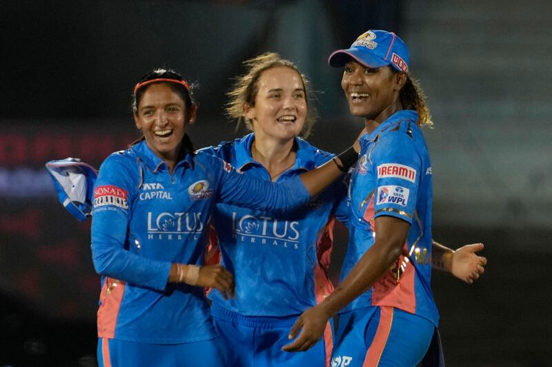 Mumbai Indians captain Harmanpreet Kaur, left, Amelia Kerr, centre, and Hayley Matthews celebrates the dismissal of Delhi Capitals' Arundhati Reddy. AP