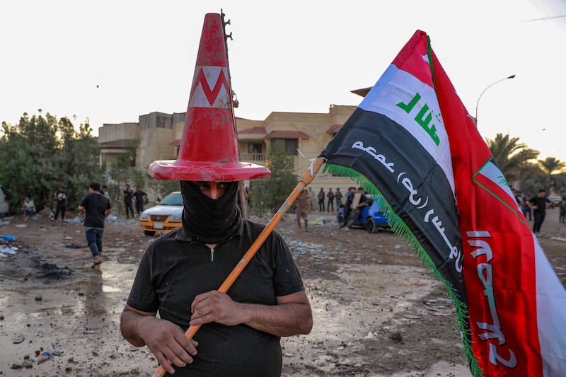 A protester wearing a traffic cone and holding an Iraqi flag outside the Swedish embassy in Baghdad. AFP