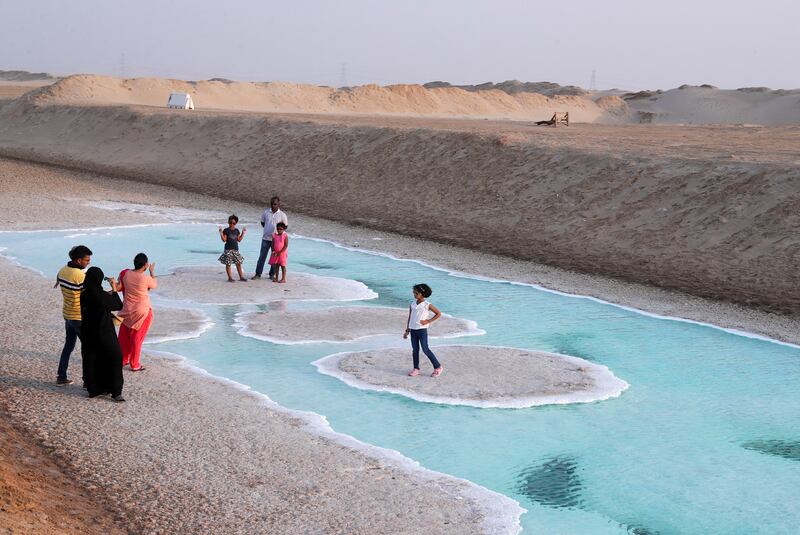 Families visit Abu Dhabi's salt lake flats at sunset. Khushnum Bhandari / The National