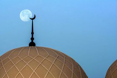 The moon rises in the sky behind rhe Saeed Mohammed Al Khalili Mosque at Khalifa City, Abu Dhabi. Victor Besa / The National