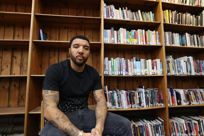 Footballer Troy Deeney, at Brixton Library in south London, in front of a book case, the book on the left hand side represents the extent of diverse history taught at Key stage 3 compared to the right section which forms part of the Brixton library's black history section. Deeney has launched a petition calling for the teaching of Black, Asian and Minority Ethnic histories and experiences to be made mandatory in the school curriculum, on February 23.