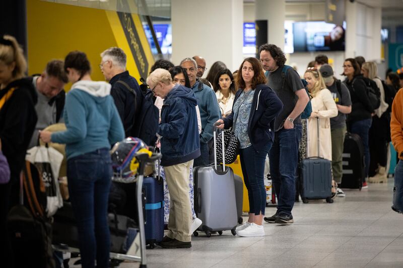 Travellers queue to check in for their flights at Gatwick. EPA