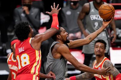 Brooklyn Nets forward Kevin Durant (7) tries to tip the ball in with Atlanta Hawks forwards John Collins (20) Solomon Hill (18) defending during the fourth quarter of an NBA basketball game, Wednesday, Dec. 30, 2020, in New York. (AP Photo/Kathy Willens)