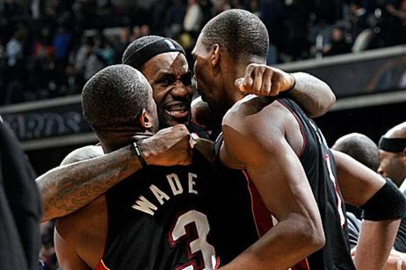 LeBron James, centre, celebrates with Dwyane Wade and Chris Bosh after Miami Heat defeated the Washington Wizards on Saturday.