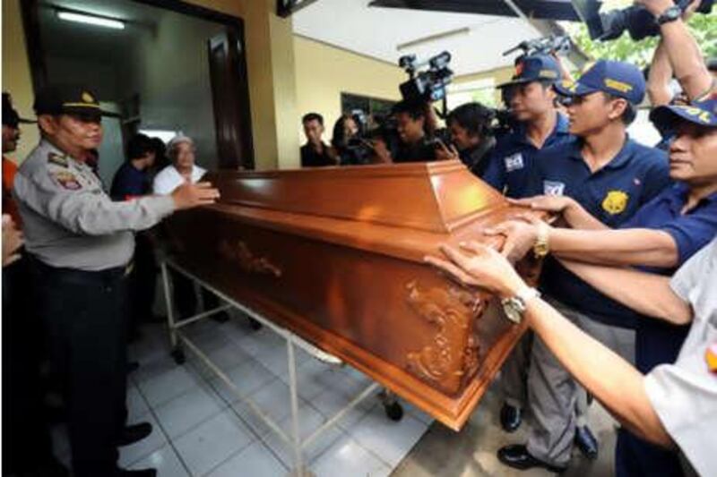 Officials push the coffin of the dead terror suspect Yuli Kartono who was killed in one of two raids in Klaten, on Thursday, June 24, 2010.