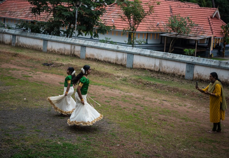 Girls in traditional attire dance as their mother shoots a video to mark Onam, outside a Hindu temple in Kochi, Kerala. AP