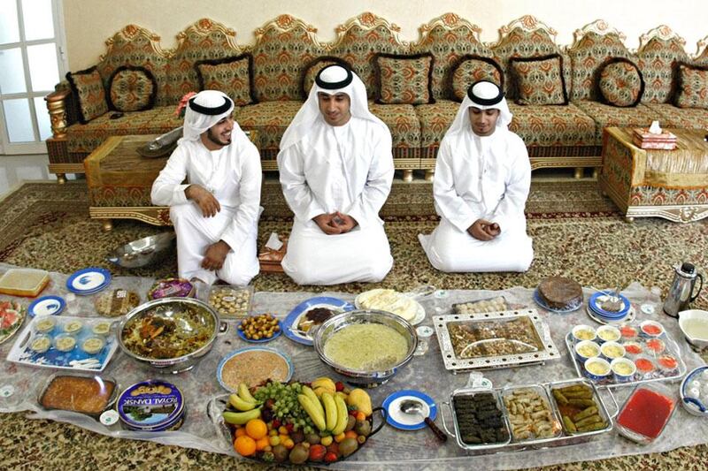 Ras Al Khaimah - August 30, 2011- Brothers Ali Saeed and Abdullah Al Qaishi with sweets and other foods to celebrate EID with family and friends in the home near Rams, Ras Al Khaimah, August 30, 2011. (Photo by Jeff Topping/The National) 

 