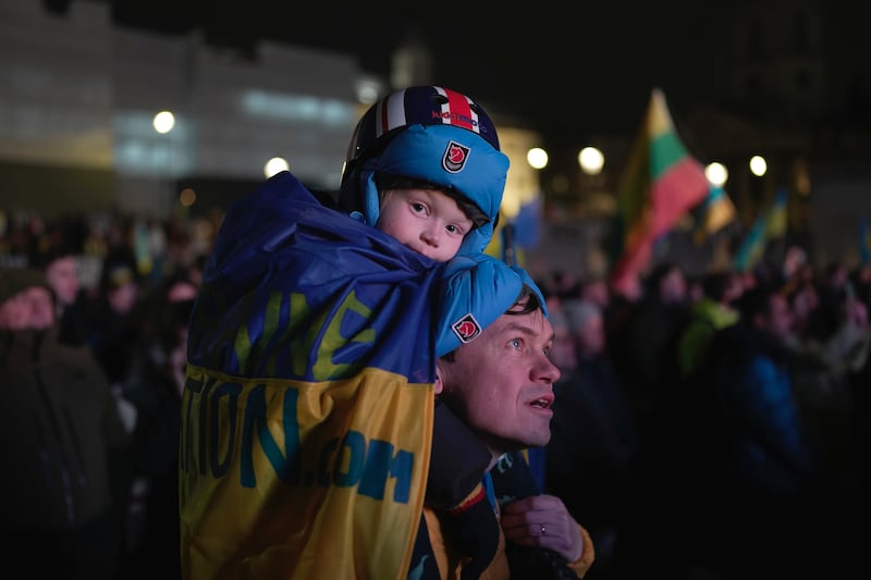A father carries a child on his shoulders at the vigil. AP