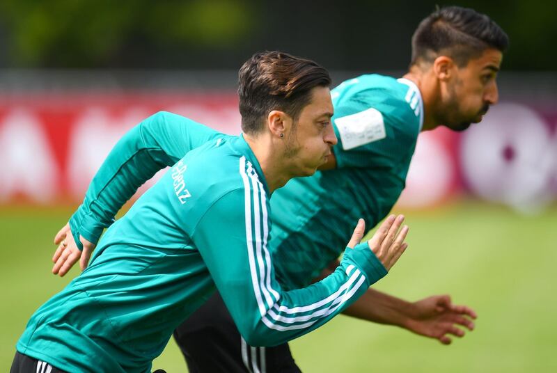 Germany's midfielders Mesut Ozil (L) and Sami Khedira warm up during a training session in Vatutinki, near Moscow, on June 14, 2018, ahead of the Russia 2018 World Cup football tournament. 
  - 
 / AFP / Patrik STOLLARZ
