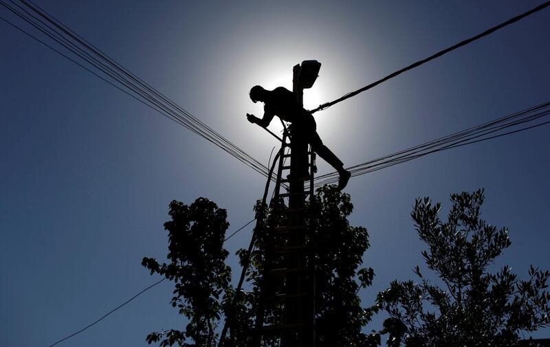 FILE PHOTO: An Iraqi technician works on an electricity pole damaged during fighting between Iraqi forces and Islamic state fighters, in eastern Mosul, Iraq April 26, 2017. REUTERS/Danish Siddiqui/File Photo