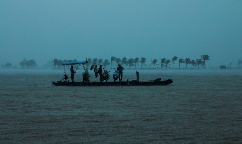 Residents are being evacuated from their home to a safer place following floods warnings, on a wooden boat at Kadamakkudi near Kochi in the Indian state of Kerala on August 10, 2019.  Floods have killed at least 100 people and displaced hundreds of thousands across much of India with the southern state of Kerala worst hit, authorities said on August 10. / AFP / STR
