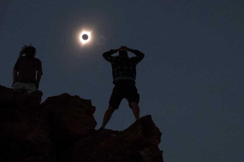 Enthusiasts Tanner Person, right, and Josh Blink, both from Vacaville, California, watch a total solar eclipse while standing atop Carroll Rim Trail at Painted Hills, a unit of the John Day Fossil Beds National Monument, near Mitchell, Oregon. Adrees Latif / Reuters