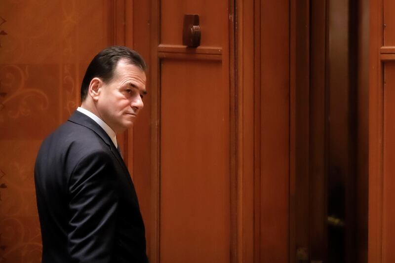 Romanian Prime Minister Ludovic Orban leaves after losing a no-confidence vote in parliament in Bucharest, Romania, Wednesday, Feb. 5, 2020. Romania's centrist government led by centrist Prime Minister Ludovic Orban lost a no-confidence vote in parliament on Wednesday, a development that raises the prospect of early elections. (AP Photo/Vadim Ghirda)