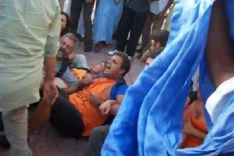 Spanish activists (on the ground) from the SaharAcciones association take part in a pro-independence demonstration in Laayoune, Western Sahara on 28 August, 2010. The Spaniards were making an attempted protest "in favour of the Sahrawi people and respecting human rights." The Canary Islands-based SaharAcciones accused Moroccan police of "savagely attacking" the group, before arresting them and driving them to the police station. Western Sahara, a former Spanish colony annexed by Morocco in 1975, is at the centre of conflict between the separatist Algerian-backed Polisario Front and Rabat, which is willing to accord broad autonomy, but not independence.
AFP PHOTO/Akhbar Elyoum