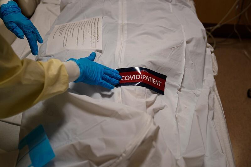 A hospital worker places a sticker on a body bag holding a deceased patient at Providence Holy Cross Medical Center in Los Angeles, US. AP Photo