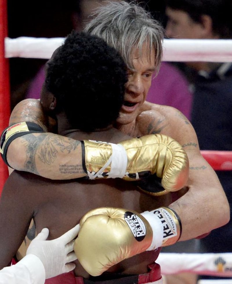 Mickey Rourke, right, 62, hugs US professional Elliot Seymour, 29, after knocking him out in Moscow. Rouke returned to boxing as a professional for eight matches in the 1990s, causing damage to his face that necessitated surgery and changed his appearance. Alexander Nemenov / AFP photo