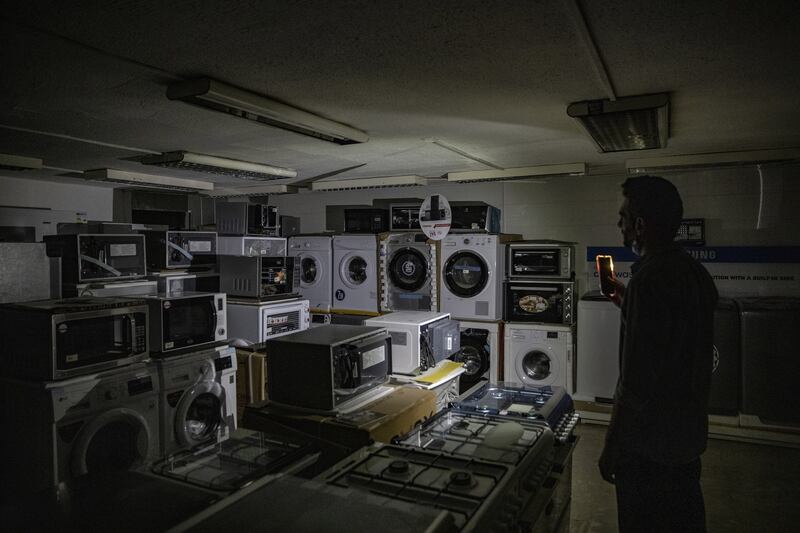 An electrical goods shop sits in darkness as residents eagerly await electricity being restored.