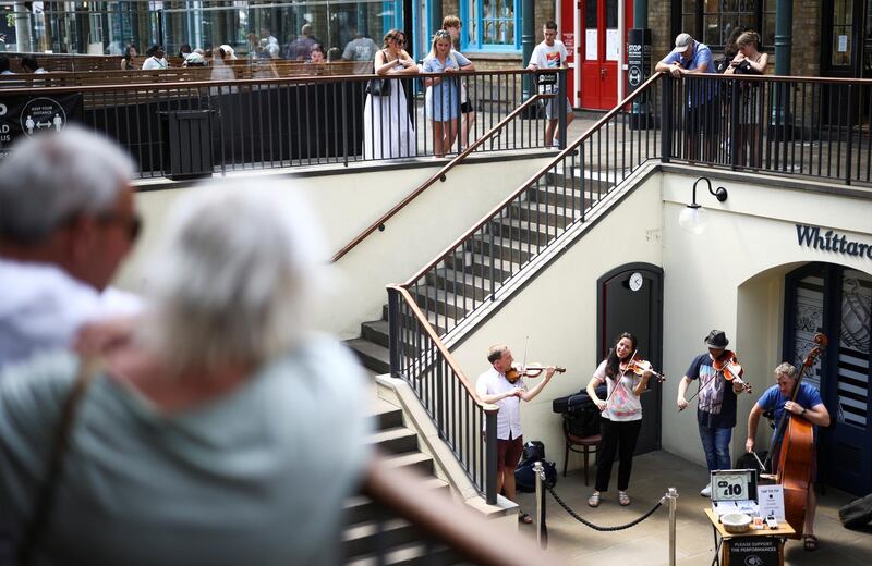 People watch a string quartet play in Covent Garden, London. Reuters