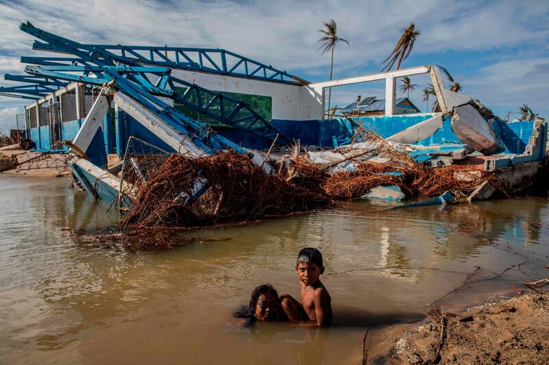 Kids bathe next to a destroyed house in Haulover in the Northern Caribbean Autonomous Region, Nicaragua. AFP