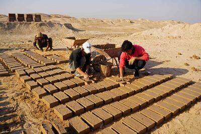 Workers make traditional clay bricks as they take part in a German-Iraqi archaeological expedition to restore the white temple of Anu in the Warka site in Iraq's Muthanna province, in November. Photo: AFP
