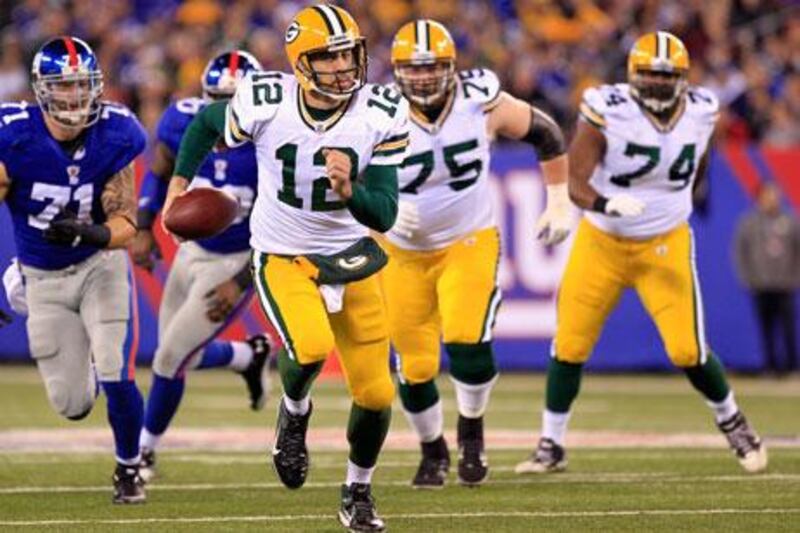 The Giants kept knocking Aaron Rodgers, centre, down, but in the end it was the Green Bay quarterback who delivered a knock-out blow.