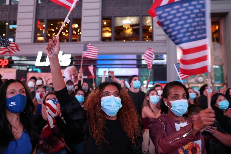 People react as they watch a speech by Democratic U.S. presidential nominee Joe Biden in Times Square after news media announced he has won the 2020 U.S. presidential election in Manhattan, New York, U.S., November 7, 2020. Picture taken November 7, 2020. REUTERS/Caitlin Ochs