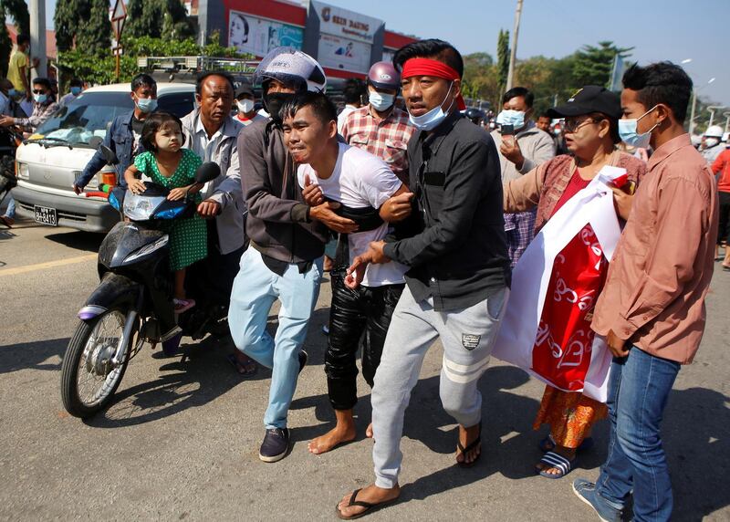 An injured protester is helped by his fellow protesters, at a rally against the military coup and to demand the release of elected leader Aung San Suu Kyi, in Naypyitaw, Myanmar. Reuters