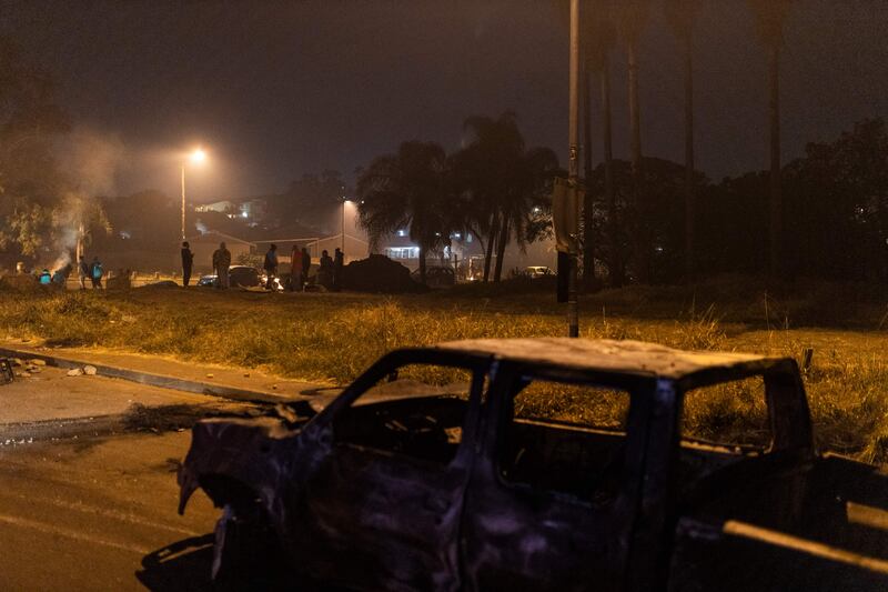 Armed community members gather at a road block in Phoenix Township, North Durban, on July 15, 2021 set up to prevent looters from reaching the community.  - Armed community members and vigilante groups have stepped in to tackle unrest in South Africa, taking matters into their own hands and sometimes stoking violence as security forces struggle to restore order. 
Understaffed and heavily reliant on private security companies, the police was rapidly overwhelmed when riots and looting first flared last week in the southeastern province of KwaZulu-Natal (KZN), sparked by the jailing of graft-accused former president Jacob Zuma.