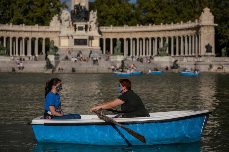 People sail a boat at the Retiro park in Madrid, Spain. AP Photo